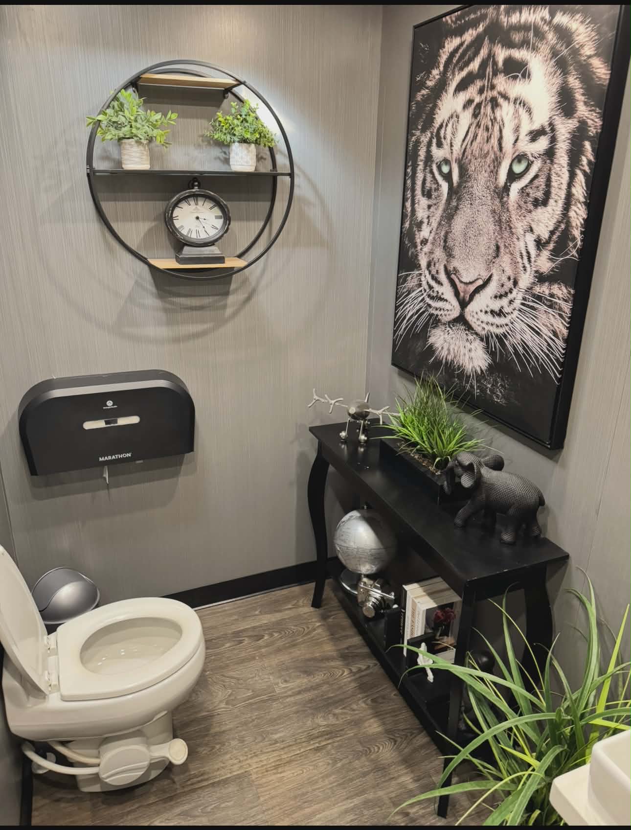 KLASSIK Restrooms 2-Unit Men's Suite Interior — Tiger Canvas Art, Round Shelf, Black Console Table, Wood Floors